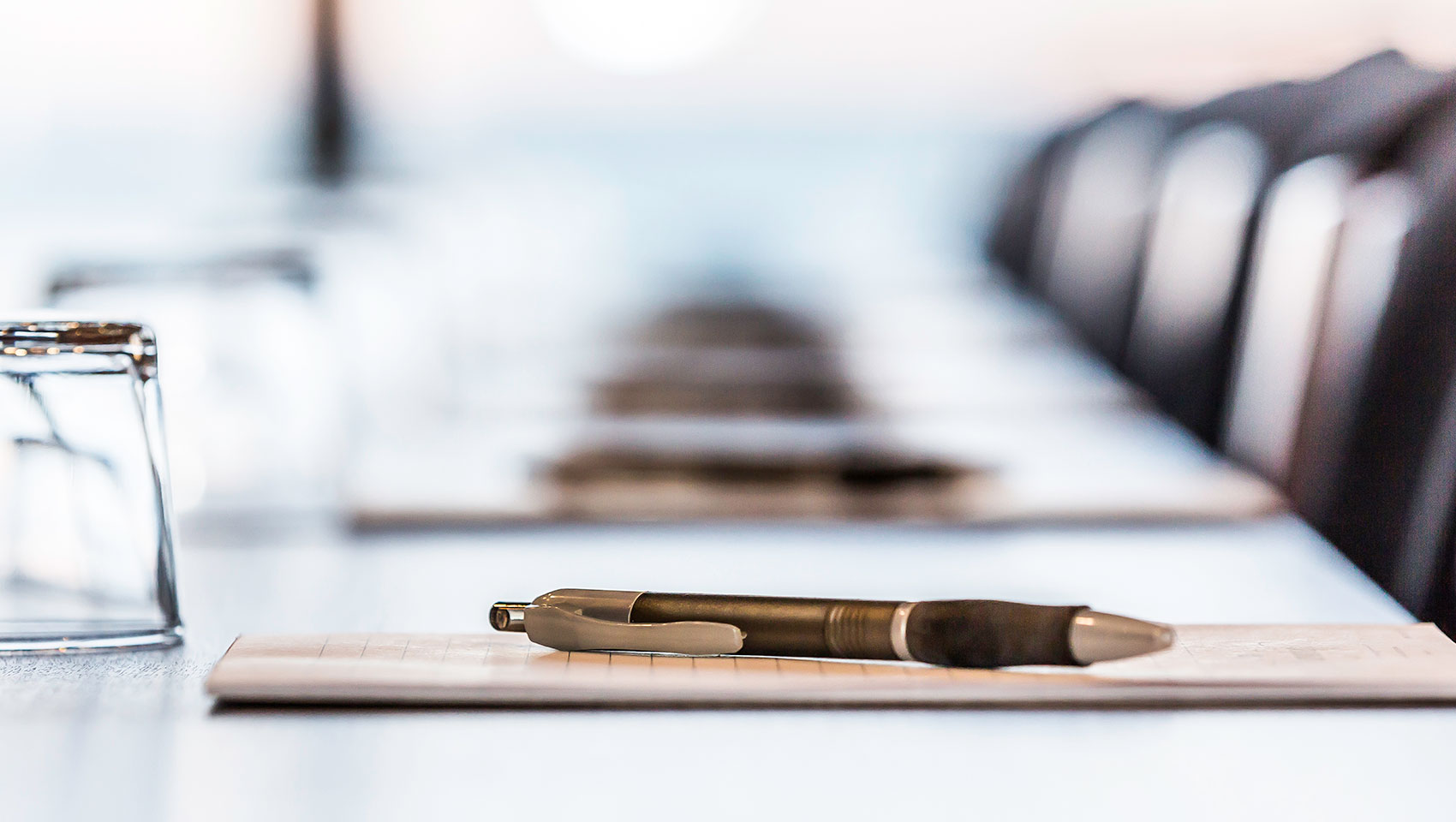 pen and paper on conference room table