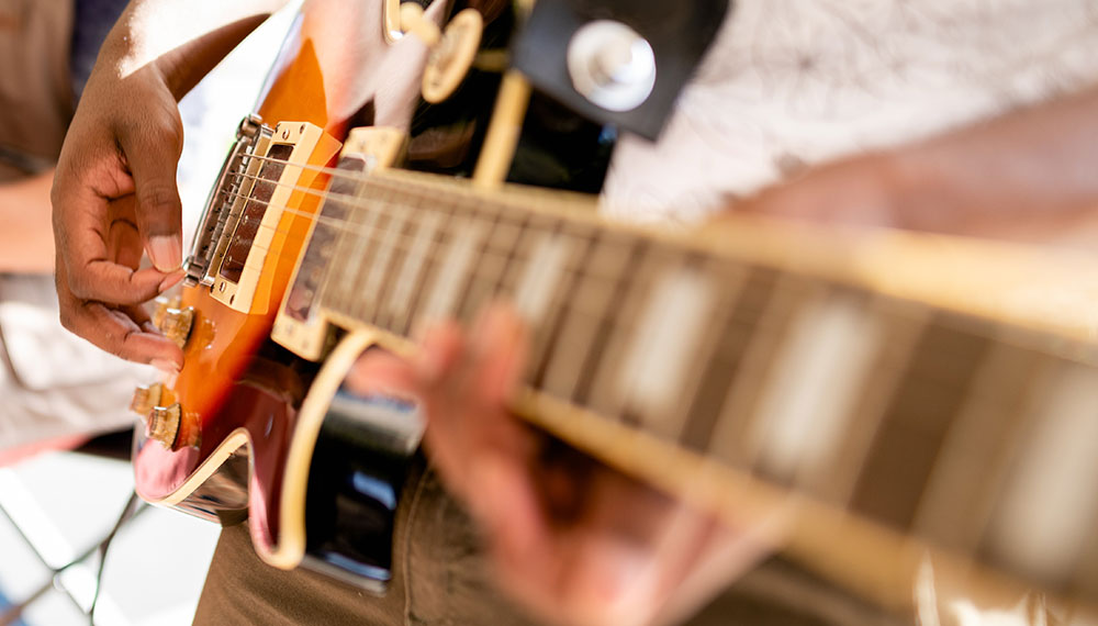 close up of a man playing a guitar