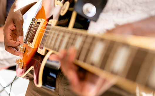 close up of person playing a guitar